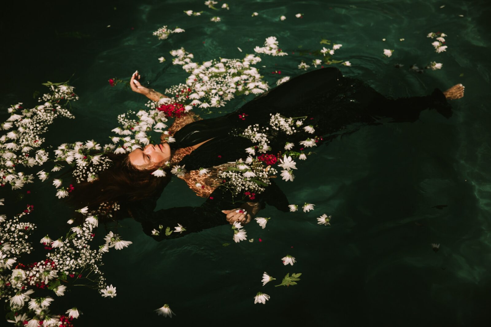 female mannequin swimming in water with flowers