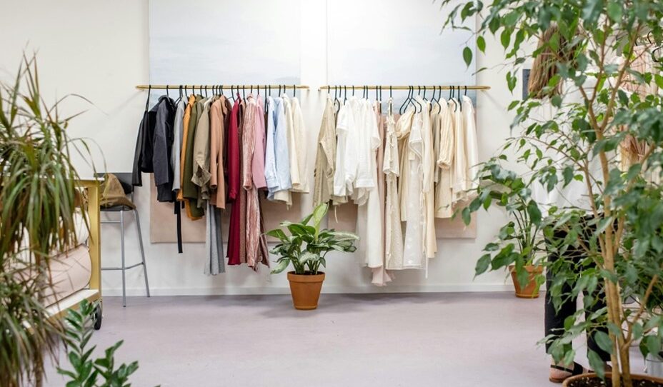 clothes displayed on hanger inside of room full of house plants