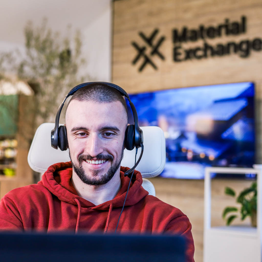Material Exchange employee with headset smiling and talking with client