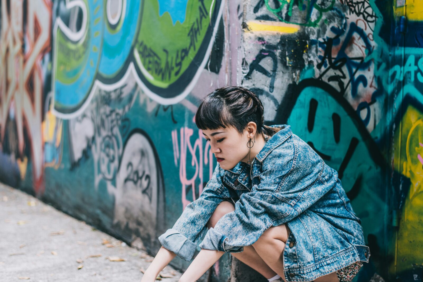 woman in denim jacket by graffiti wall, deadstock guide