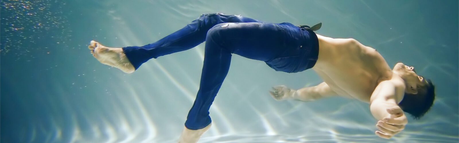 Swimming man in jeans, water-conscious denim