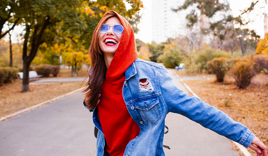 Smiling woman in denim jacket and red sweatshirt